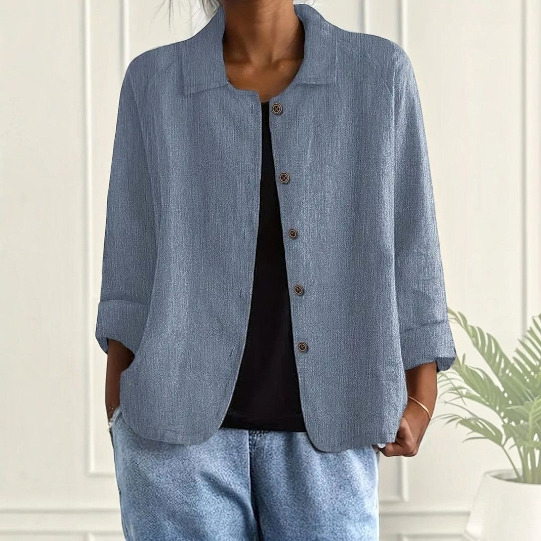 Blusa Lars Hamburg Wilhelmine azul com textura enrugada, gola pontiaguda, botões tonais e bolsos frontais.
