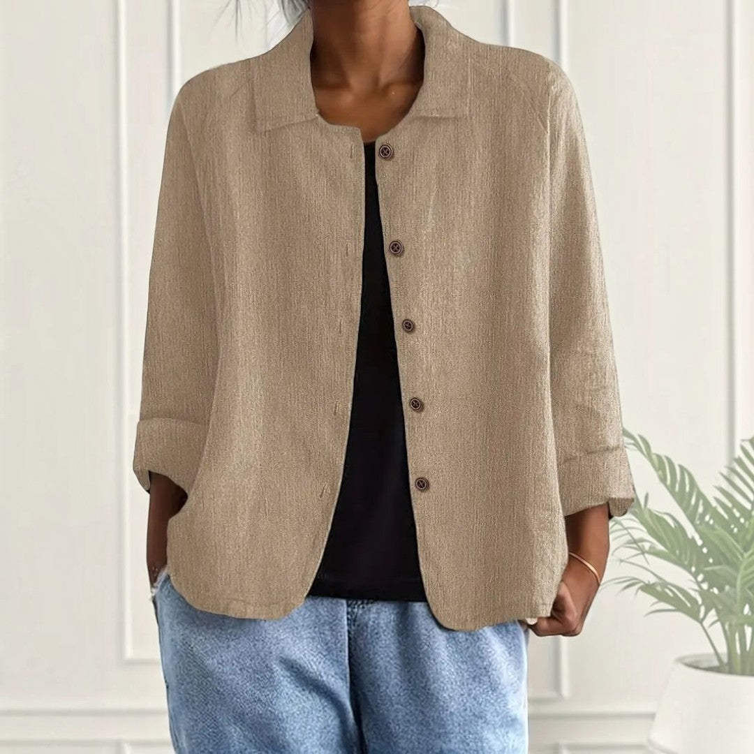 Blusa Lars Hamburg bege com textura crinkle, corte boxy, colarinho clássico e bolsos laterais, usada aberta.