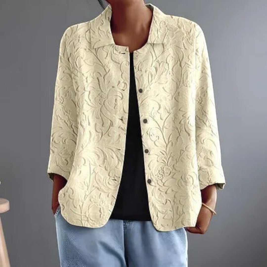 Blusa Lars Hamburg Delphinette em tom marfim com padrão floral em relevo, gola pontiaguda e botões tonais.