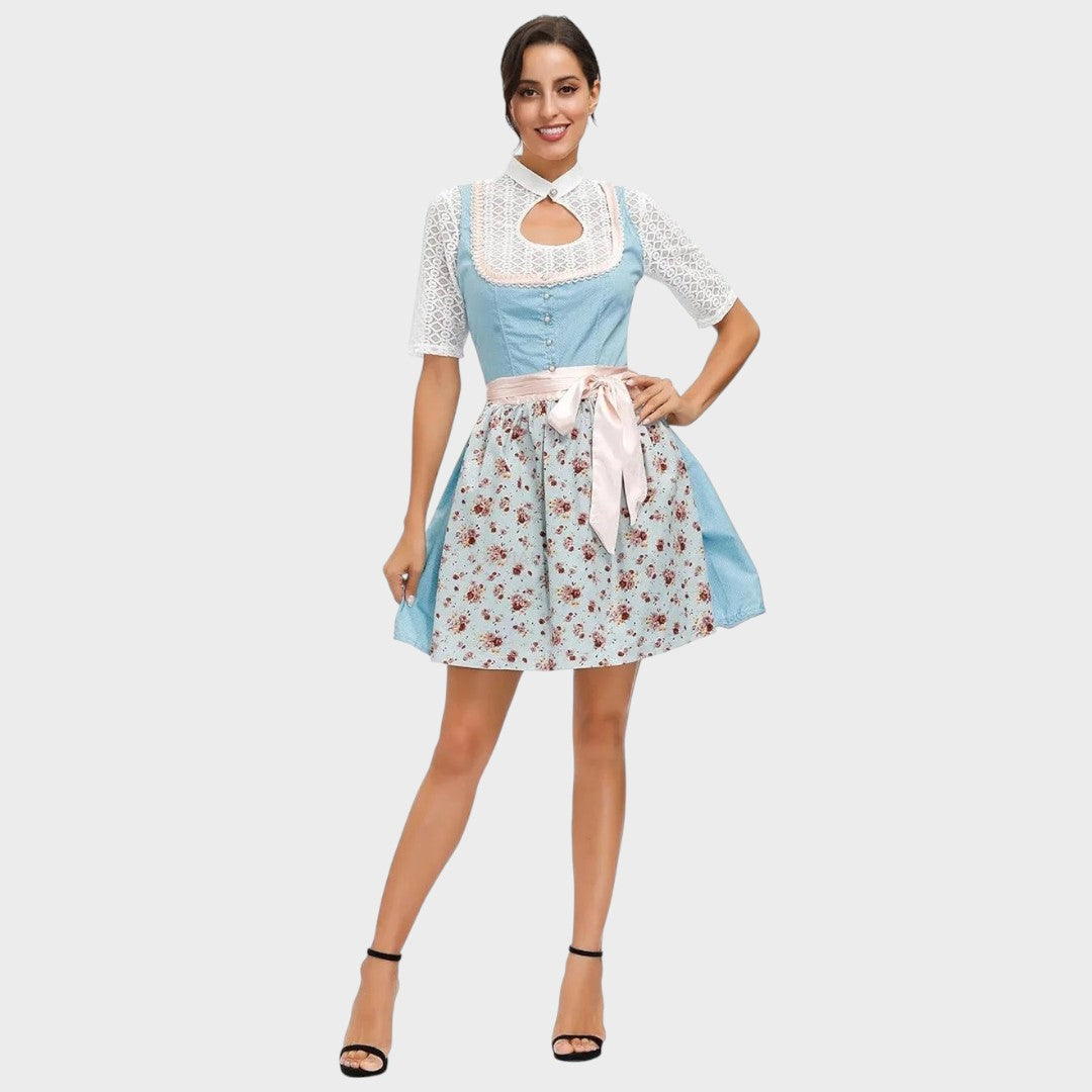 Modelo veste Dirndl Lars Hamburg azul e floral com mangas de renda branca e avental rosa para Oktoberfest