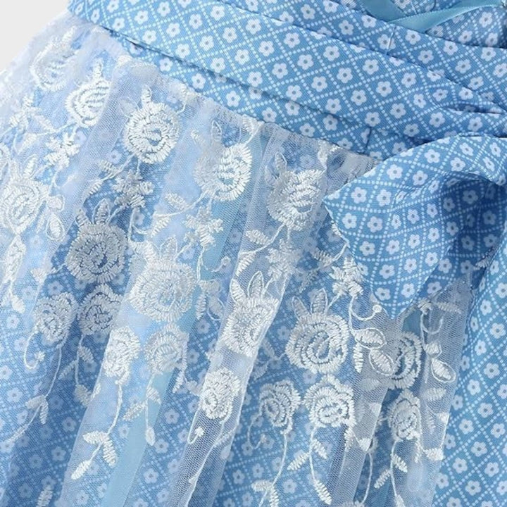 Detalhe de Dirndl Lars Hamburg azul com padrão floral e avental de renda branca com bordados de flores