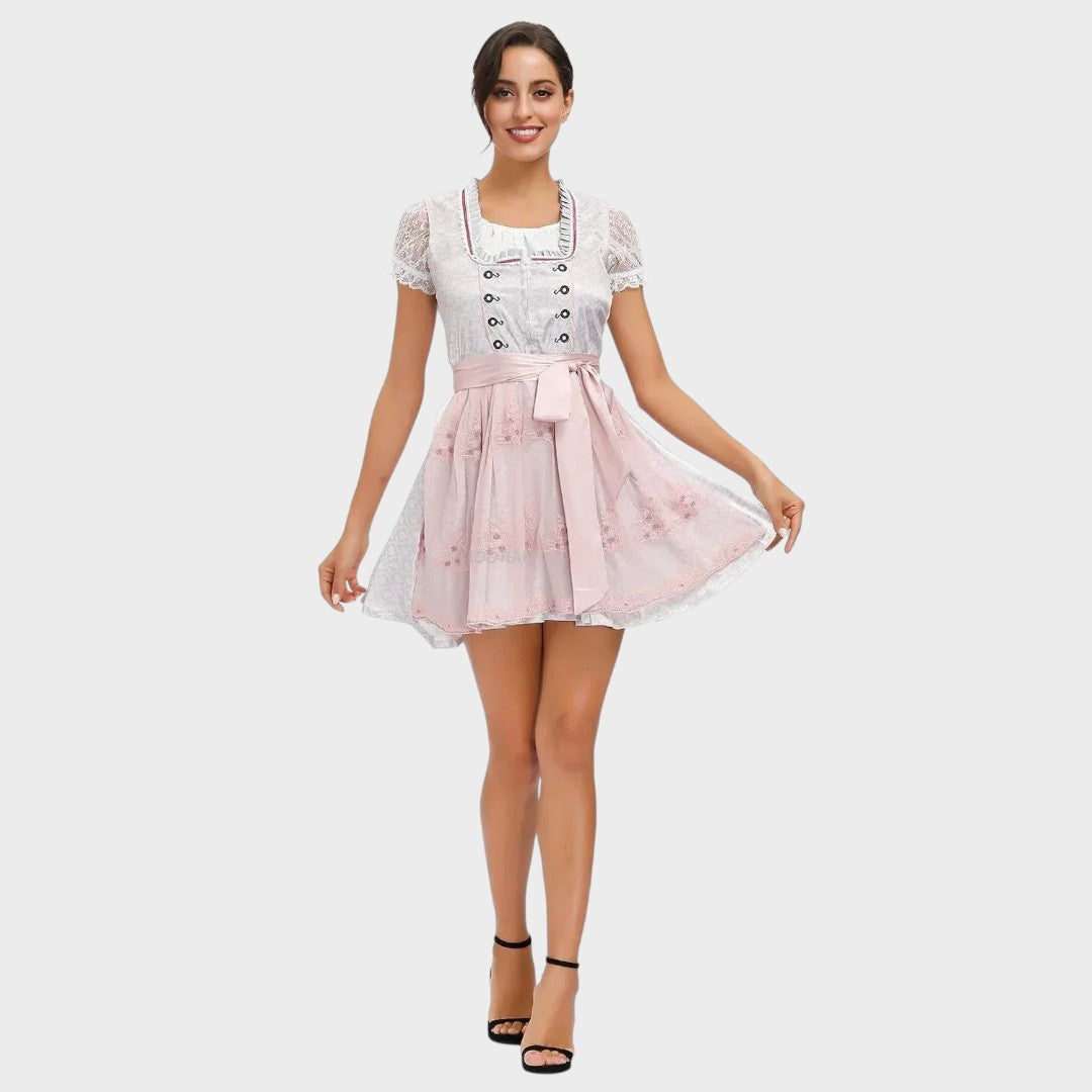 Modelo veste Dirndl Lars Hamburg branco e rosa com detalhes em renda, mangas curtas e avental para Oktoberfest.