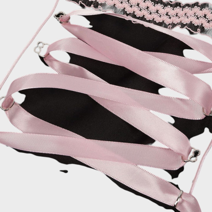 Detalhe do laço de fita rosa acetinada no corpete de um dirndl Lars Hamburg com acabamento em renda preta