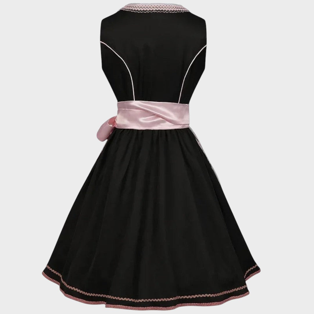 Vista traseira do Dirndl Lars Hamburg preto com detalhes em rosa fúcsia, cinto de cetim e padrão floral na bainha.