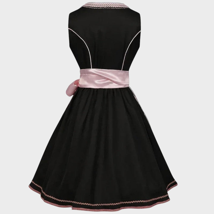 Vista traseira do Dirndl Lars Hamburg preto com detalhes em rosa fúcsia, cinto de cetim e padrão floral na bainha.