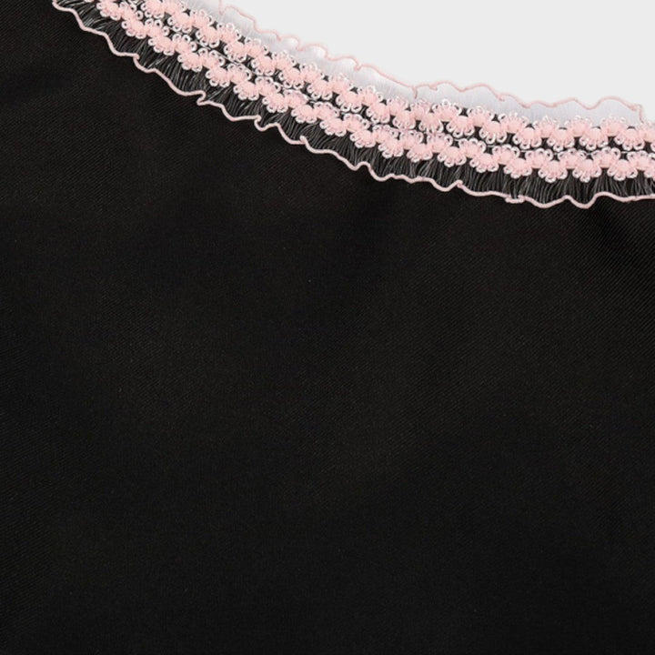 Detalhe do decote de um dirndl Lars Hamburg preto com acabamento em renda delicada na cor rosa claro