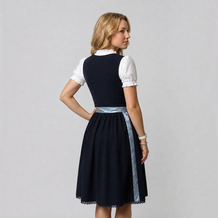 Vista traseira de um Dirndl tradicional Lars Hamburg em cinzento escuro com avental, blusa branca e detalhes em renda.