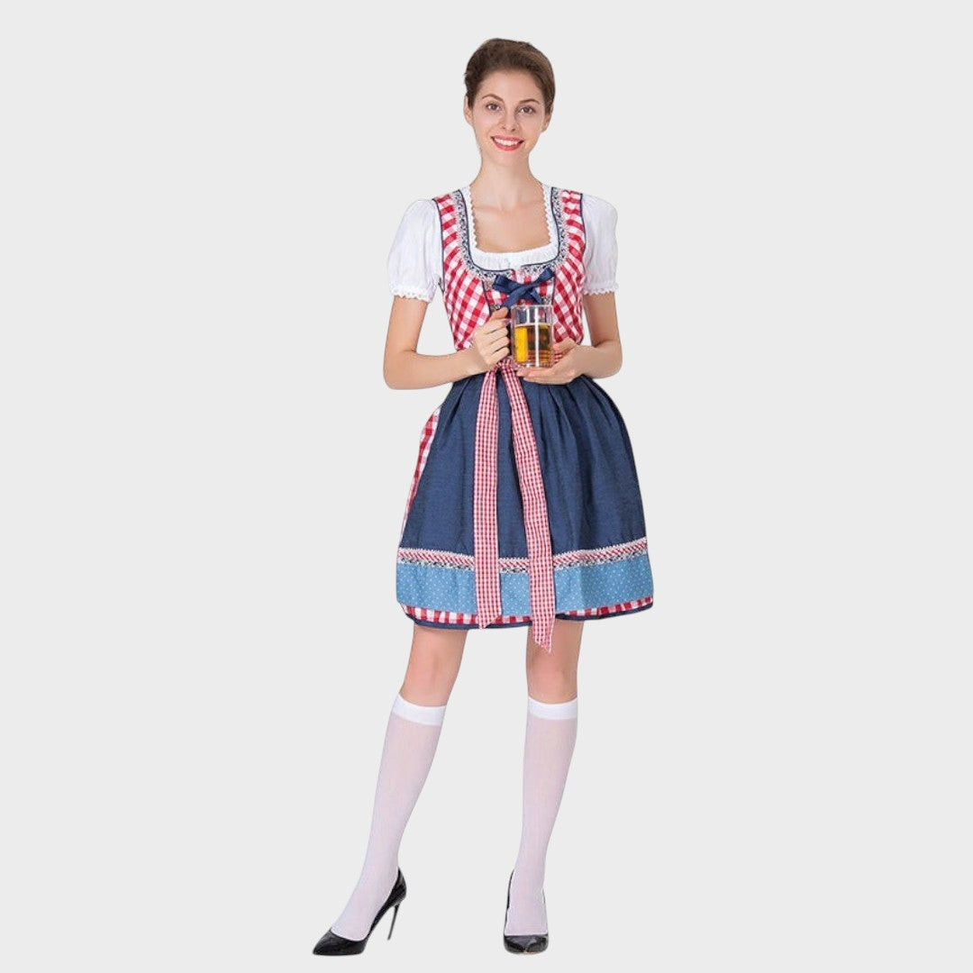 Modelo vestindo Dirndlkleid da Lars Hamburg com avental xadrez, blusa branca e caneca de cerveja em fundo cinza.