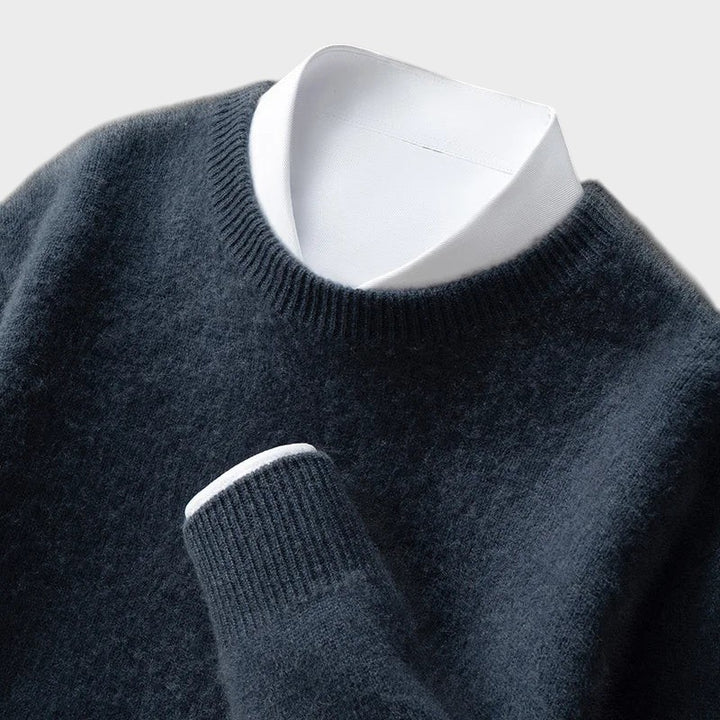 Pullover Andrzej da marca Lars Hamburg em malha azul escura macia com gola redonda e camisa branca por baixo