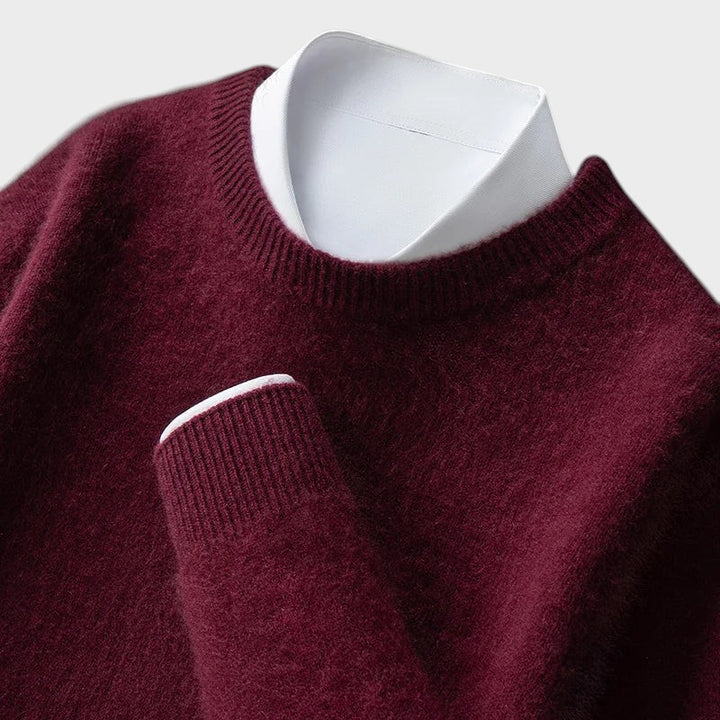Pullover Andrzej da Lars Hamburg em tom bordô com textura macia, gola redonda e camisa branca por baixo.
