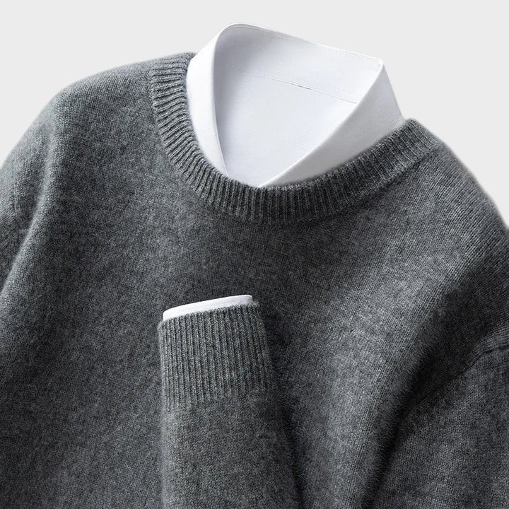 Pullover cinzento Lars Hamburg com gola redonda e punhos canelados, sobreposto a uma camisa branca formal.