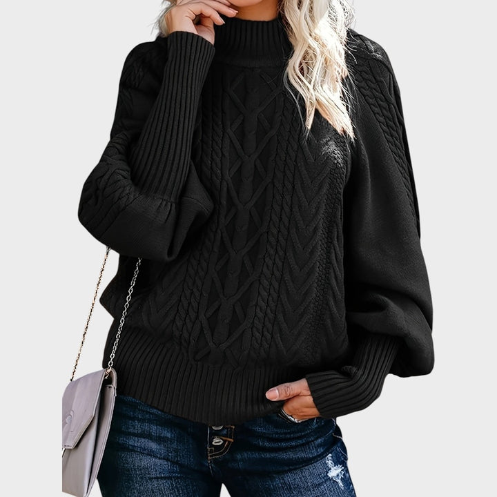 Pullover de malha preto Lars Hamburg com gola alta, padrão de tranças e mangas compridas, combinado com calças de ganga.