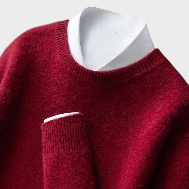 Pullover Andrzej da Lars Hamburg em vermelho escuro com gola redonda e punhos canelados sobre camisa branca.