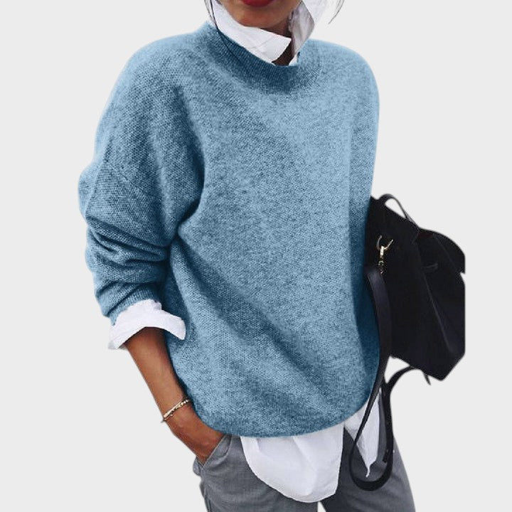 Pulôver azul de malha macia Lars Hamburg com gola redonda, usado sobre camisa branca e calças cinzentas.