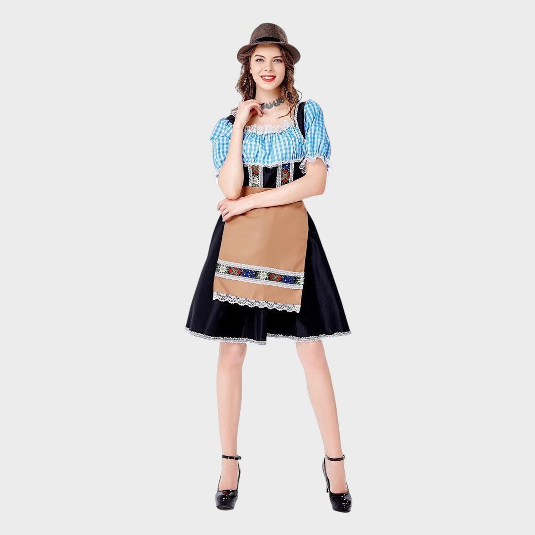 Modelo veste vestido Trachtenkleid Lars Hamburg preto com avental bege, mangas xadrez azul e detalhes bordados.