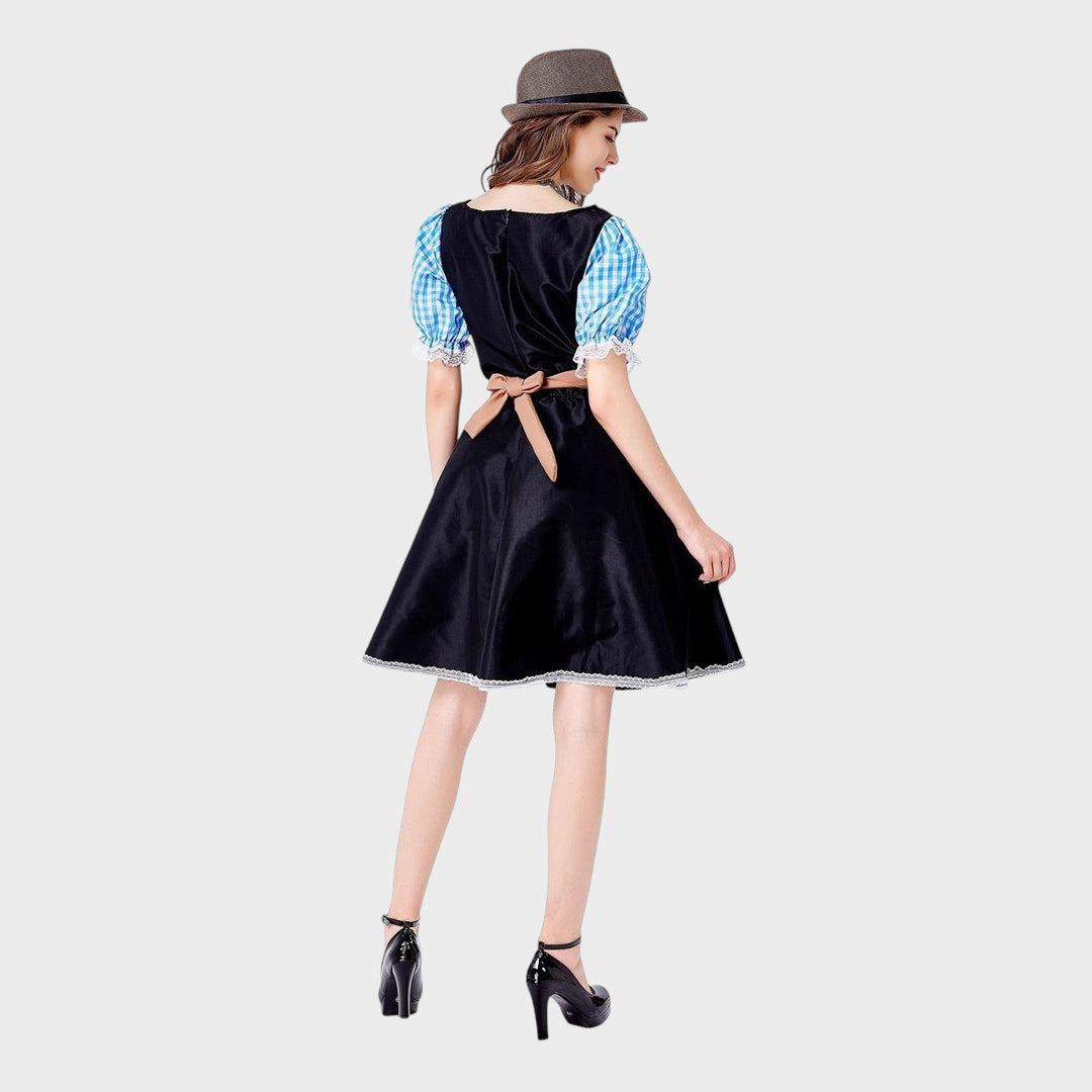 Modelo de costas vestindo vestido de Trachten Lars Hamburg preto com mangas xadrez azul e avental castanho