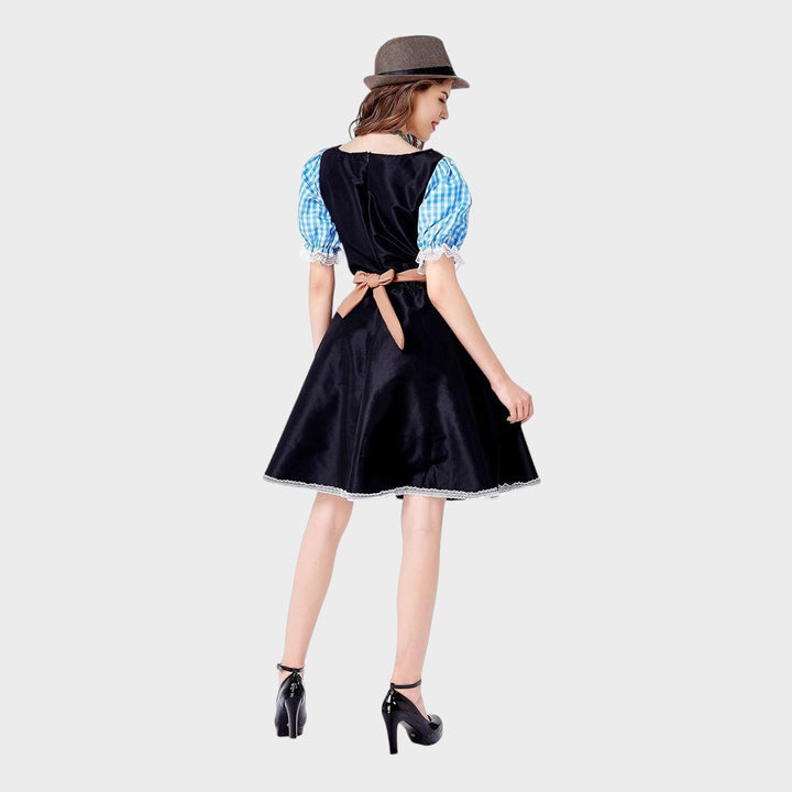 Modelo de costas vestindo vestido de Trachten Lars Hamburg preto com mangas xadrez azul e avental castanho
