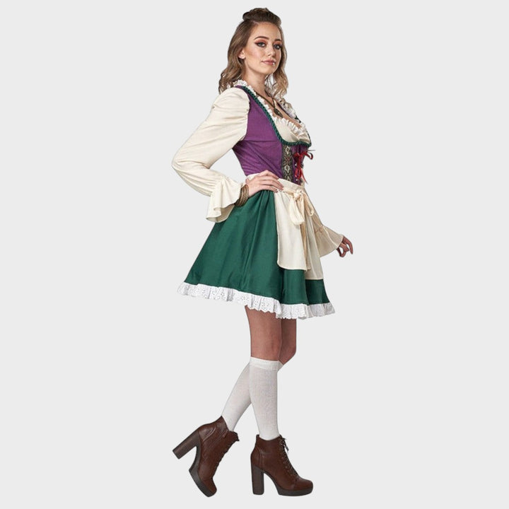 Modelo veste vestido tradicional Lars Hamburg com corpete roxo, saia verde, mangas creme com babados e cinto na cintura