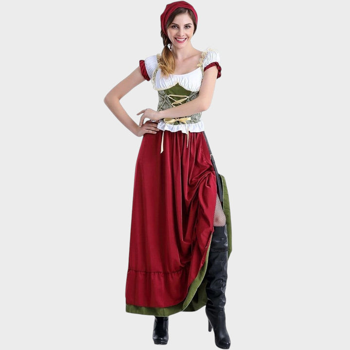 Mulher a usar traje tradicional bávaro Lars Hamburg com corpete verde, saia vermelha e lenço de cabeça a condizer.