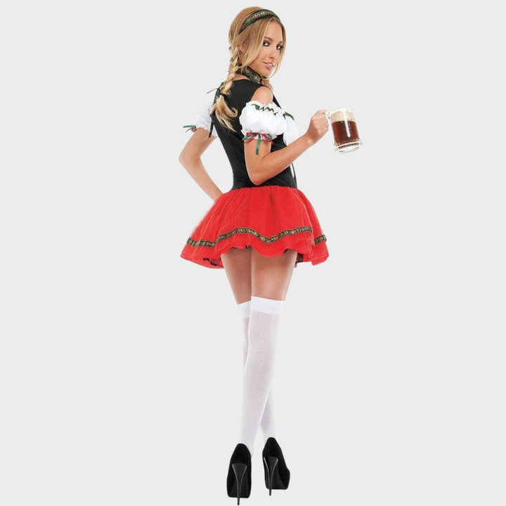 Modelo com traje tradicional Lars Hamburg, vestido com corpete preto, saia vermelha volumosa e caneca de cerveja