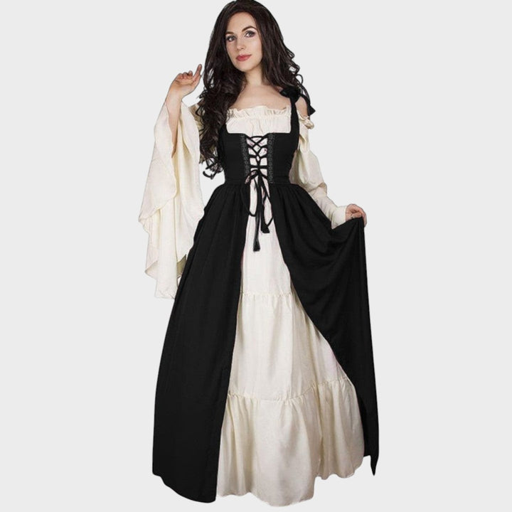 Modelo veste vestido histórico Lars Hamburg em bege e preto com mangas largas, decote em V e detalhe de cordões.