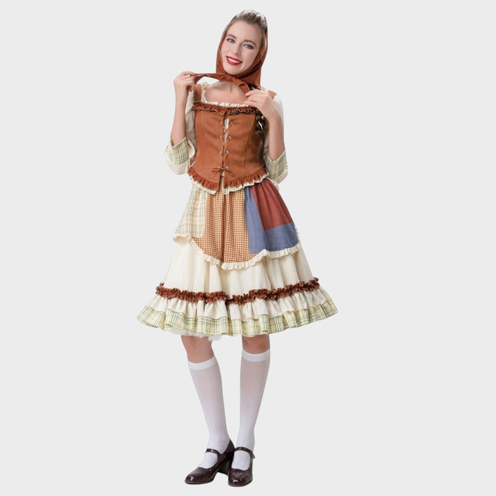 Modelo veste vestido tradicional Lars Hamburg com corpete castanho, saia de patchwork e lenço de cabeça a condizer.