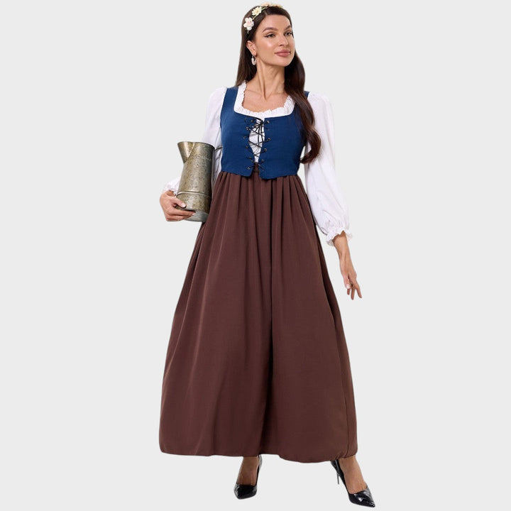 Modelo veste vestido tradicional Lars Hamburg com corpete azul, mangas brancas e saia longa castanha em fundo neutro