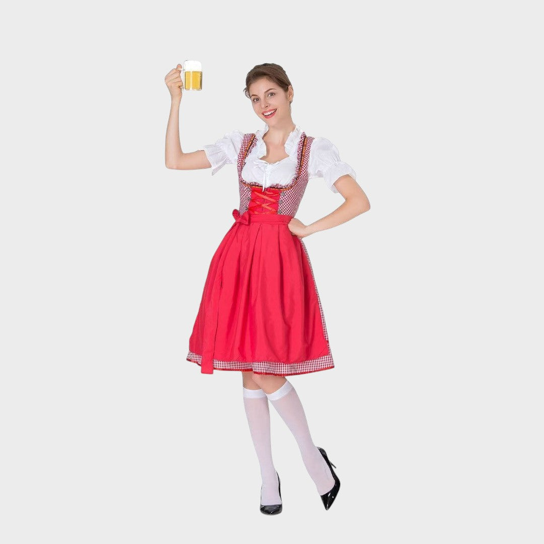 Modelo sorridente com vestido tradicional Lars Hamburg vermelho e branco com padrão xadrez e avental, segurando caneca