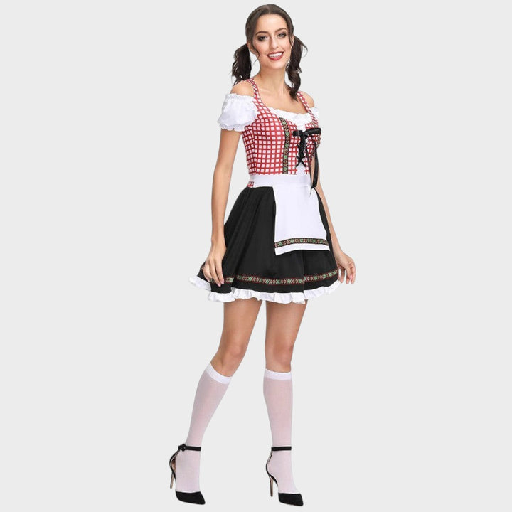Modelo veste vestido tradicional Lars Hamburg com corpete xadrez vermelho, saia preta com folhos e mangas bufantes.