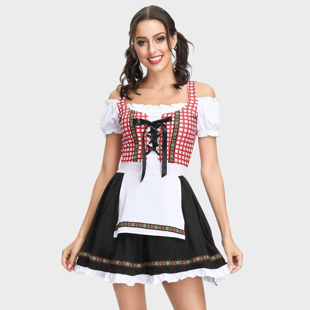 Modelo veste vestido tradicional Lars Hamburg com corpete xadrez vermelho, mangas bufantes e saia preta com babados.