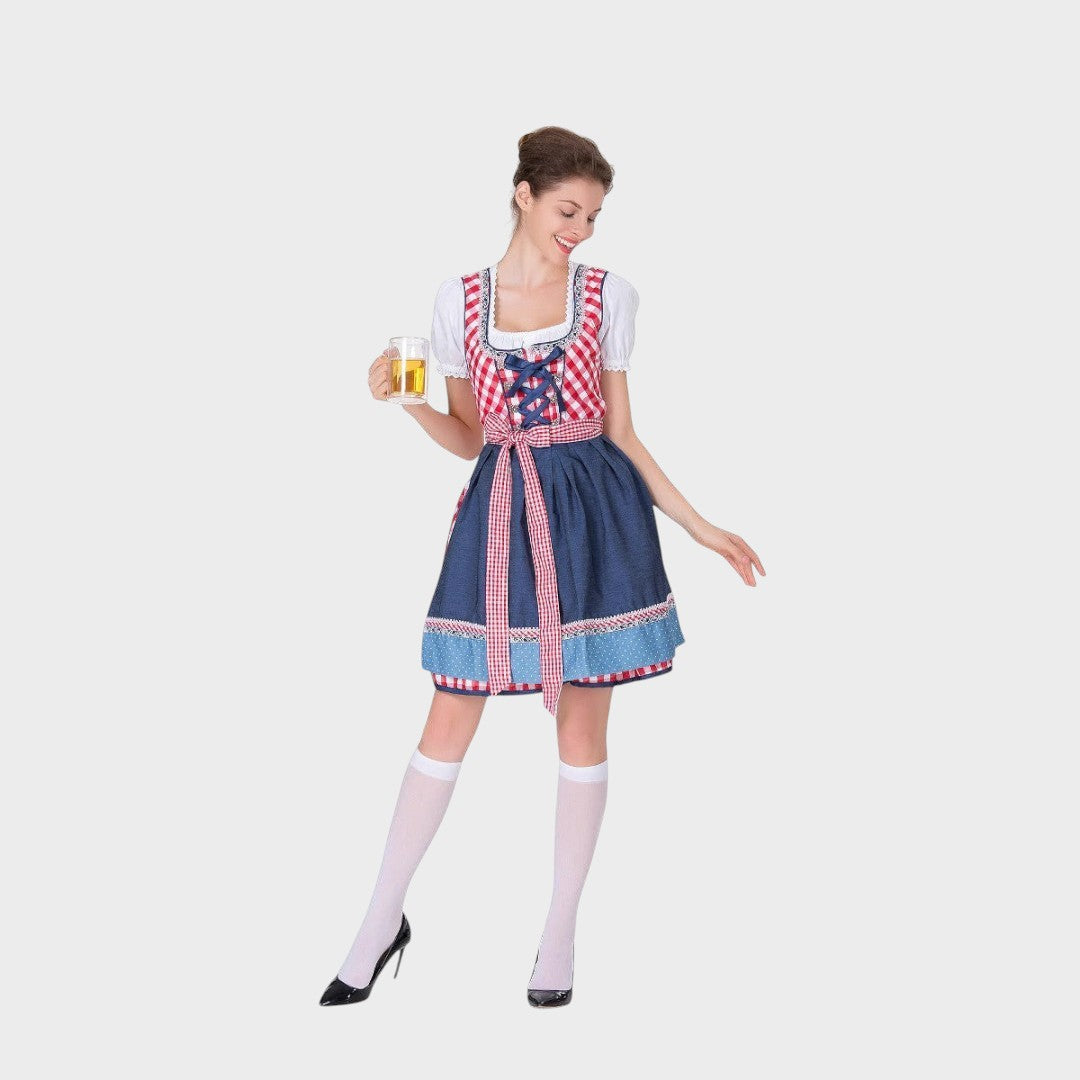 Modelo vestindo vestido tradicional Lars Hamburg com corpete xadrez vermelho, saia azul e avental, segurando caneca